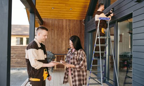 Female client signing document about payment for work of maintenance service group