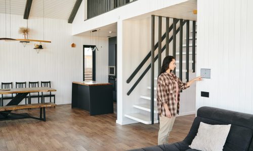 Young woman looking at home security panel or screen in living-room
